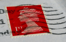 Image d’un timbre rouge symbolisant affranchissement lettre suivie.