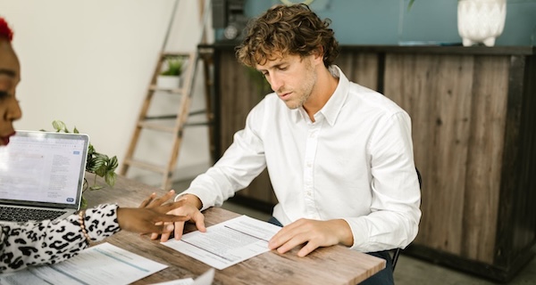 Un homme lit le contrat après avoir envoyé une lettre pour fermer un compte bancaire.