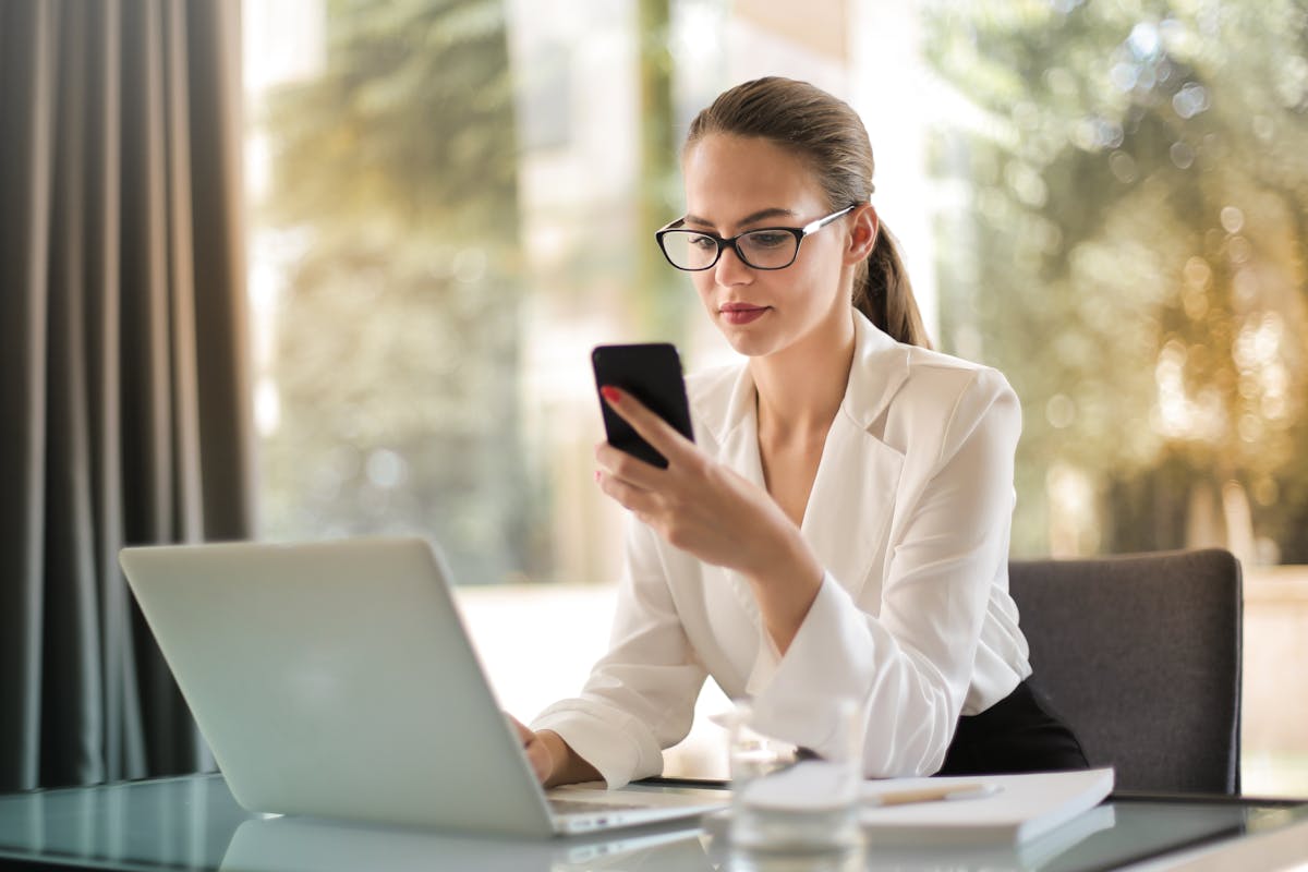 Une femme cherche à contacter sa banque par téléphone.