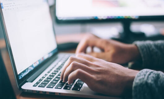 Un chercheur d’emploi rédige une lettre de demande d’emploi après avoir préparé sa lettre de motivation
