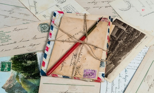 Le timbre sur une carte postale est apposé, et le courrier est prêt à être envoyé.
