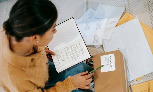 Une femme prépare ses documents pour envoyer une lettre à la CAF.