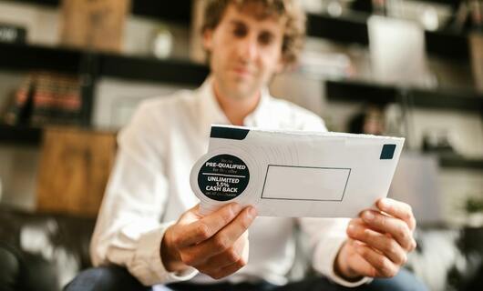Un homme tient dans ses mains l’enveloppe de sa lettre de demande de remboursement.