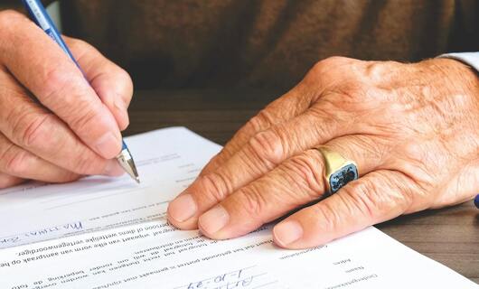 Un homme écrit une lettre au maire pour lui faire une demande d'aide.