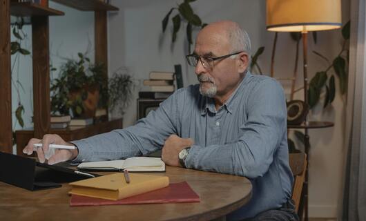 Un homme âgé rédige sa lettre de départ à la retraite.