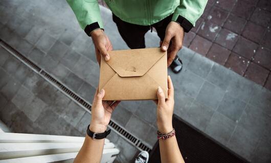 Le facteur livre une lettre de préavis à un locataire de la part du propriétaire.
