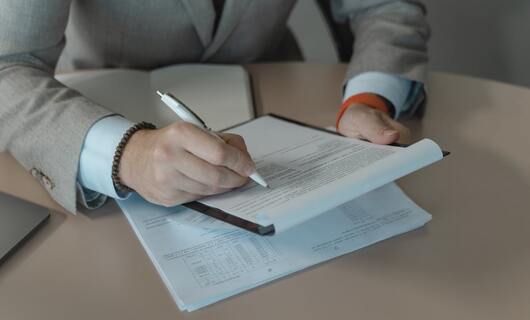 Un homme revoit ses notes avant d'envoyer la lettre de refus à une candidature.