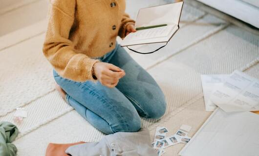 Une femme prépare ces documents pour rédiger une lettre hébergement à titre gratuit.