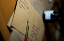Une enveloppe marron prête à être affranchie, se trouvant sur une table, contient une lettre sur laquelle l'expéditeur a posé son stylo.