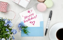 Une invitation d'anniversaire est posée sur une enveloppe, prête à être envoyée.