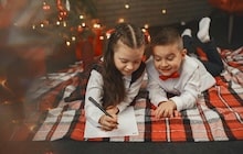 Deux enfants écrivent un courrier au Père Noël.