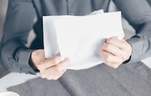 Un homme froisse sa lettre à un voisin bruyant avec colère.